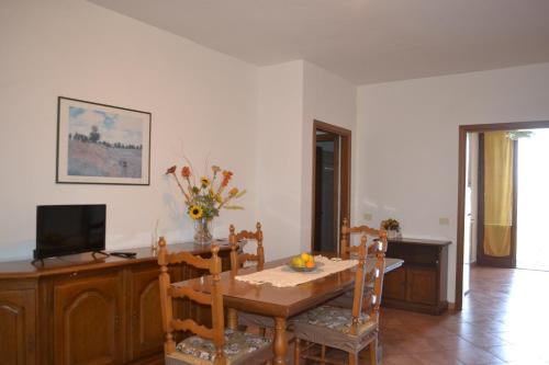 a dining room with a table and a television at Appartamento La Chiusa in Monticiano