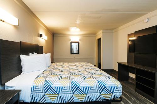 um quarto de hotel com uma cama e uma televisão de ecrã plano em Motel 6-Baytown, TX - Garth Rd em Baytown