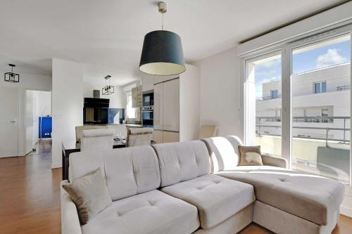 a living room with a white couch and a large window at Cosy apartment & balcony -1BR 4P- Levallois-Perret in Levallois-Perret
