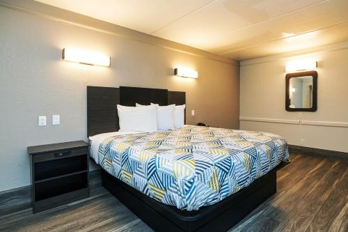 a hotel room with a bed and a mirror at Motel 6-Baytown, TX - Garth Rd in Baytown