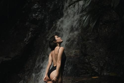 a woman standing in front of a waterfall at Terramia Estate in Minca