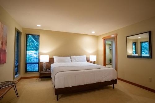 una camera con un grande letto e due finestre di Bridle Trails Treehouse a Bellevue