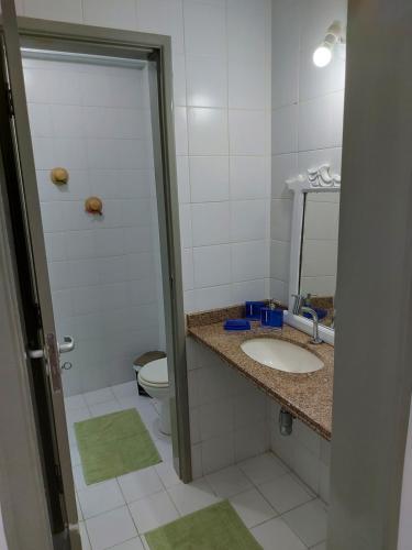a bathroom with a sink and a toilet and a mirror at Apto na Praia de Atalaia a 100 metros da Passarela do Caranguejo in Aracaju