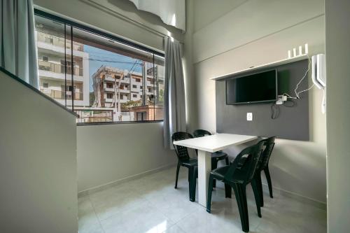 d'une salle à manger avec une table, des chaises et une fenêtre. dans l'établissement Flórida Premium, à Bombinhas