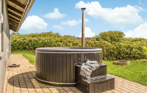 a large trash can sitting on a patio at 3 Bedroom Amazing Home In Hvide Sande in Havrvig