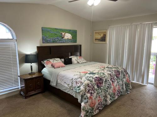 a bedroom with a bed with a floral bedspread at Beautiful 1-bedroom Townhome with nice amenities in Houston