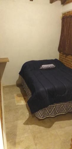 1 cama con edredón negro en una habitación en Cabaña Los Ángeles, en Huasca de Ocampo