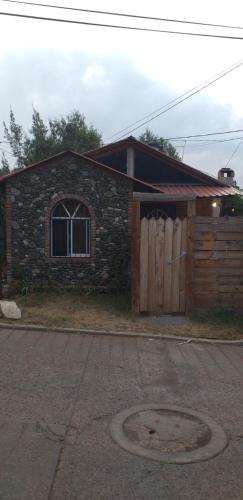 a brick house with a wooden gate and a door at Cabaña Los Ángeles in Huasca de Ocampo