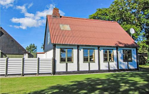 a house with a red roof and a white fence at Beautiful Home In Aakirkeby With Wifi in Spidsegård