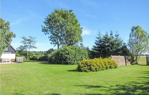 a yard with green grass and trees and bushes at Beautiful Home In Aakirkeby With Wifi in Spidsegård