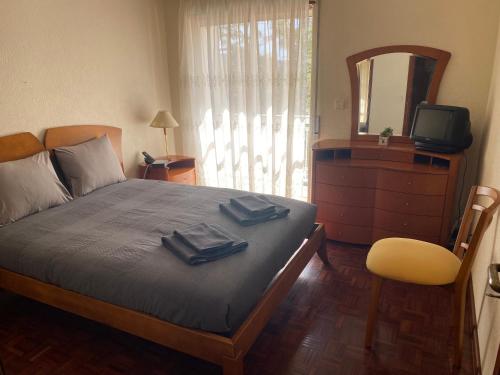 a bedroom with a bed with a dresser and a mirror at Painel da Caparica in Costa da Caparica