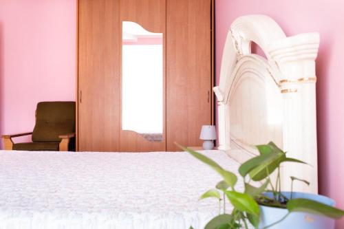 una camera con un letto bianco e una pianta di Апартаменти на Сихові, Драгана 1й a Lviv
