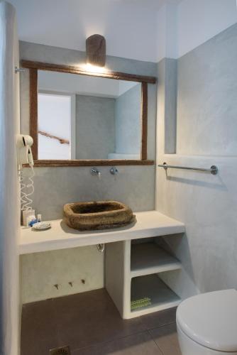 a bathroom with a sink with a mirror and a toilet at Tania Milos in Pollonia