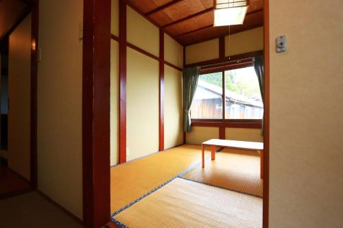 an empty room with a bench and a window at 民宿やまそ in Takashima