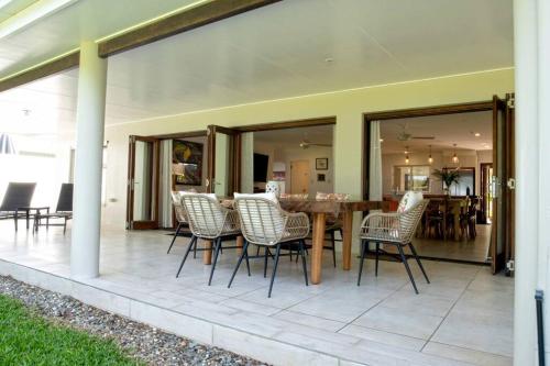 a patio with a wooden table and chairs at Alani - Absolute Beachfront - Sleeps up to 10 in Mission Beach