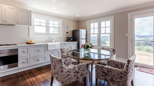 a kitchen with a glass table and some chairs at Somerleyton Cottage in Wildes Meadow