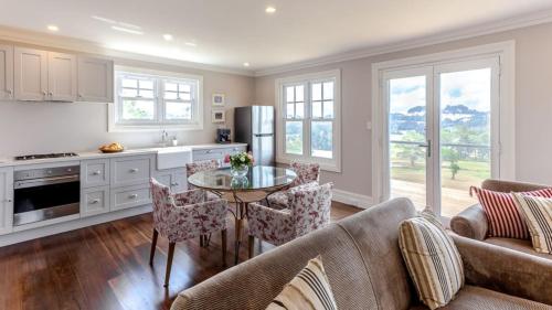 a kitchen and living room with a table and chairs at Somerleyton Cottage in Wildes Meadow