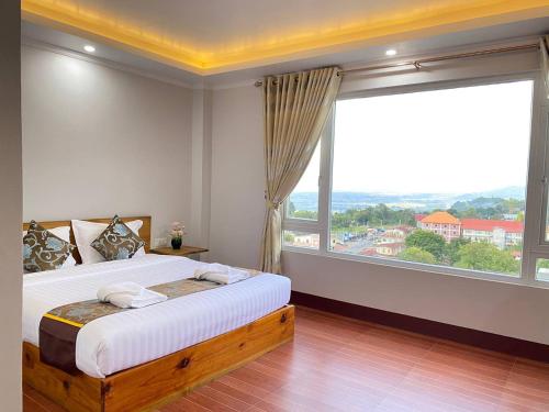 a bedroom with a bed and a large window at LOI LOUNG HOTEL in Taunggyi