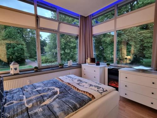 1 dormitorio con ventanas grandes y 1 cama grande en Meerblick-am Strand, im Kurpark!, en Glücksburg