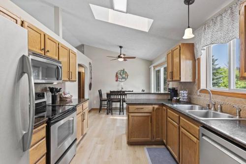 a kitchen with wooden cabinets and a stainless steel refrigerator at Hot tub! Sleeps 8-11Upscale Area in Spokane
