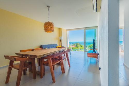 una sala da pranzo con tavolo, sedie e vista sull'oceano di New Beachfront Luxury Apartments a Cancún