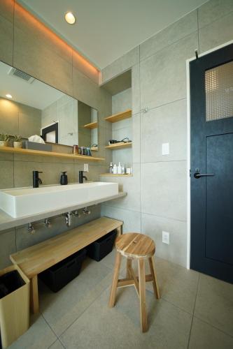 ein Badezimmer mit einem Waschbecken und einem Holzhocker in der Unterkunft Villacation the Loose in Minamiawaji