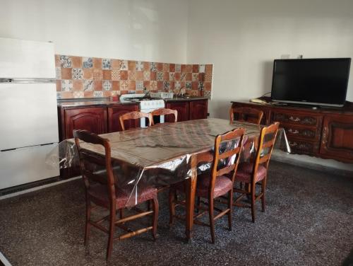 comedor con mesa, sillas y TV en Departamentos Temporarios Salta en Salta