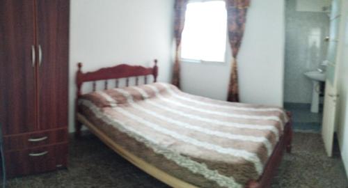 1 dormitorio con 1 cama, vestidor y ventana en Departamentos Temporarios Salta en Salta