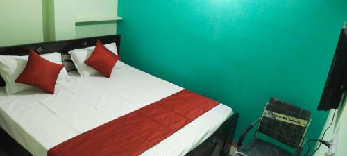 a bedroom with a bed with red and white pillows at SPOT ON Hotel Royal Garden in Dānāpur