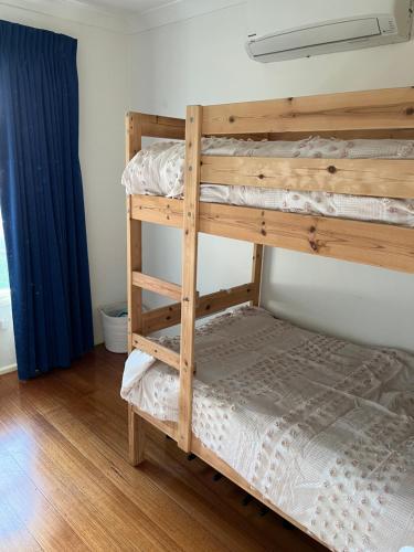 Clouston Cottage في Heathcote: سرير بطابقين في غرفة مع سرير بطابقين خشبي