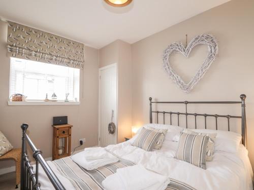 a bedroom with a bed with a heart on the wall at 18b New Street in Buckie