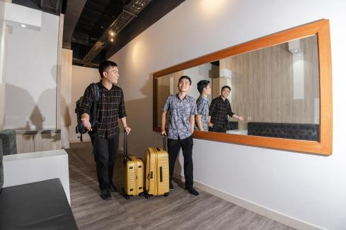 a group of men standing next to a mirror with luggage at Istanaku in Manado