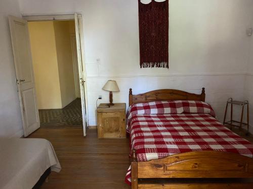 1 dormitorio con 1 cama con manta roja y blanca a cuadros en Alojarte en Punilla- Casona Azul hasta 12 personas en Huerta Grande