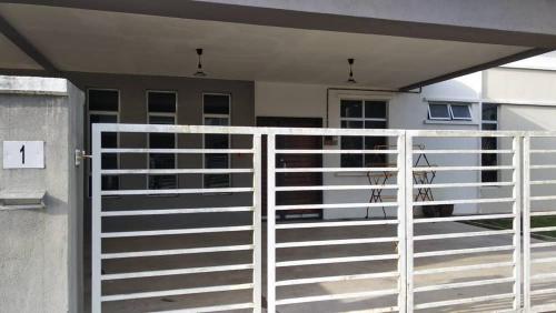 a white fence in front of a house at Casaria Homestay Cherating in Kampong Baharu Cherating