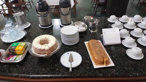 een tafel gedekt met witte borden en een brood bij Ancora Peruibe Hotel in Peruíbe