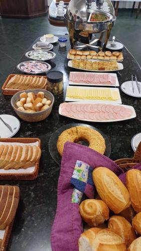 een tafel met borden brood en manden met voedsel bij Ancora Peruibe Hotel in Peruíbe