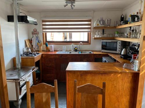 uma cozinha com armários de madeira e uma bancada em Casa Entre Ulmos y Lengas em Puerto Natales