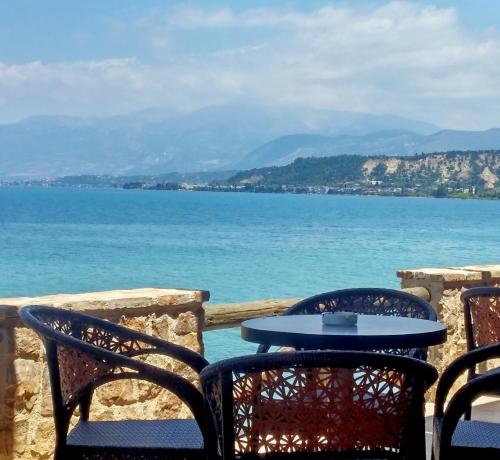 a table and chairs with a view of the ocean at Castella Beach in Alissos