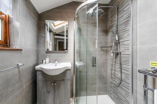 a bathroom with a sink and a shower at Nurse's Cottage in Alnwick