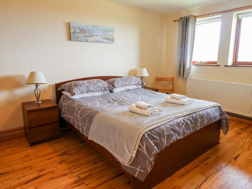 恩布爾頓的住宿－Dunstanburgh View，一间卧室配有一张床,上面有两条毛巾