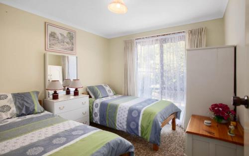 a bedroom with two beds and a window at Comfortable Elevated Holiday Home in Encounter Bay