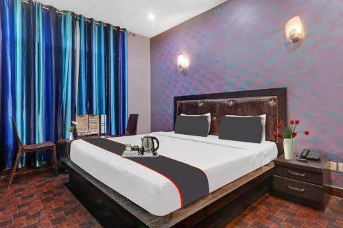 a bedroom with a large bed and blue walls at OYO Flagship Hotel Shivansh Residency in Lucknow