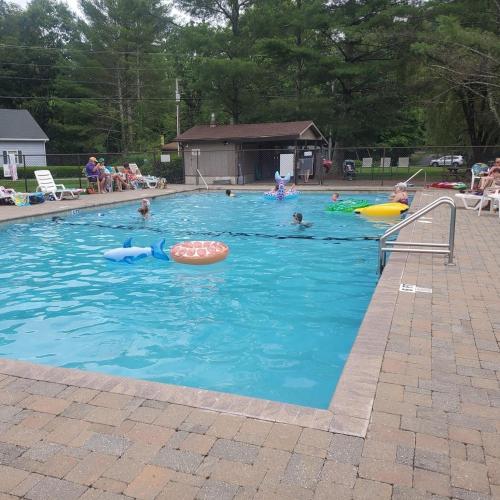 a group of people swimming in a swimming pool at King Bed, Putt-Putt w/ Hot Tub, & Other Games in Banner Elk
