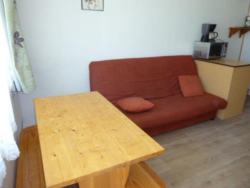 un salon avec un canapé et une table en bois dans l'établissement Studio cosy pour 4 pers. à deux pas des pistes avec kitchenette et loggia - Arette - FR-1-602-113, à Arette