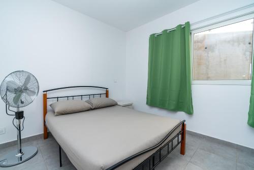 阿魯埃的住宿－Fare Taharaa 1BR in Arue，一间卧室配有一张带风扇和窗户的床。