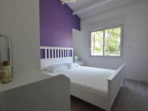 une chambre avec un lit blanc et une fenêtre dans l'établissement Charmante Villa Rénovée avec Jardin, Climatisée, Pour 8 Pers - Quartier Boisé à La Palmyre - FR-1-705-52, aux Mathes