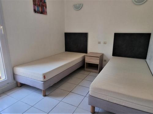 duas camas sentadas uma ao lado da outra num quarto em Appartement Cerbère, 2 pièces, 4 personnes - FR-1-309-405 em Cerbère
