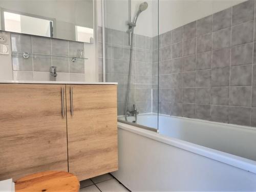 uma casa de banho com uma banheira, um lavatório e um chuveiro em Appartement Cerbère, 2 pièces, 4 personnes - FR-1-309-405 em Cerbère