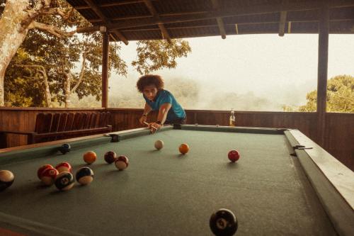 a young boy playing pool on a pool table at Hostal Sierra Minca in Minca