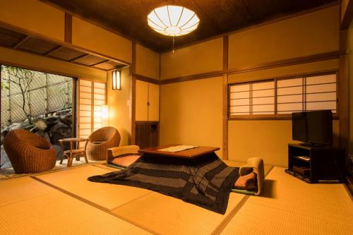 uma sala de estar com uma mesa e uma televisão em Yamagaso em Hakone